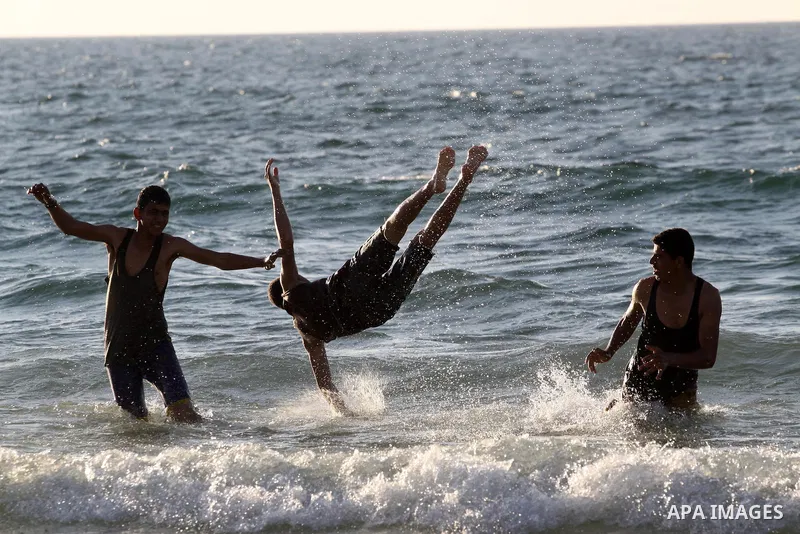 Palestinians enjoy swimming during a hot weather at the beach of Gaza city, on March 28, 2014. Photo by Mohammed Asad