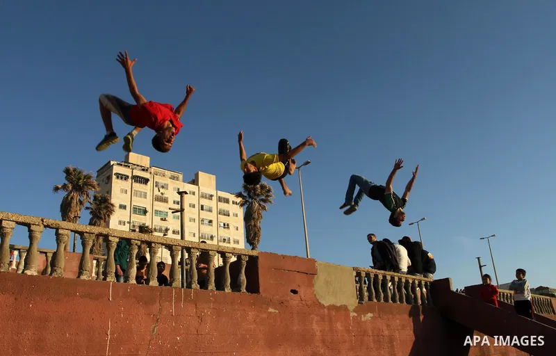 Palestinians play parkour during a hot weather at the beach of Gaza city, on March 28, 2014. Photo by Mohammed Asad