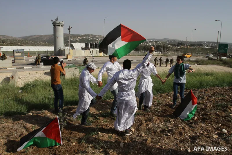 Palestinian youths dressed up as farmers participate in dancing of "Dabka" during a rally marking Land Day at Hawara checkpoint near the West Bank city of Nablus, on March 29, 2014. The annual demonstrations mark the dea...