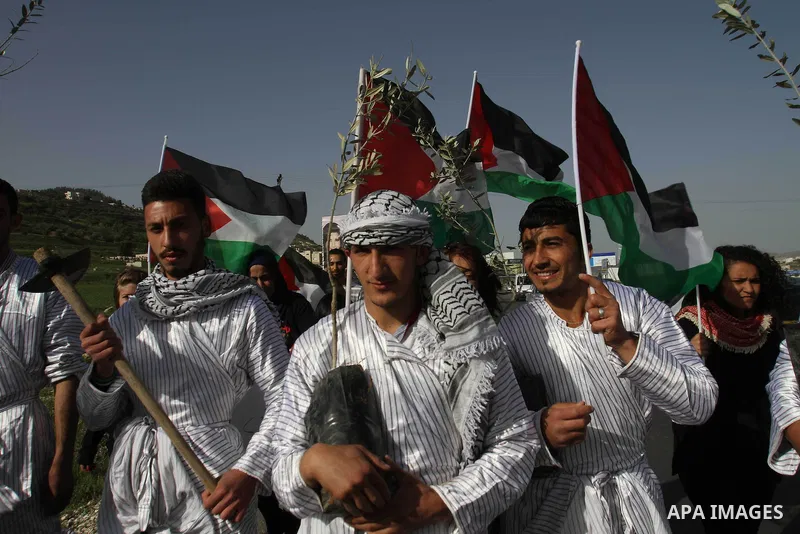 palestinian youth dressed up as farmers take part in a rally marking Land Day at Hawara checkpoint near the West Bank city of Nablus on March 29, 2013. The annual demonstrations mark the deaths of six Arab Israeli protes...