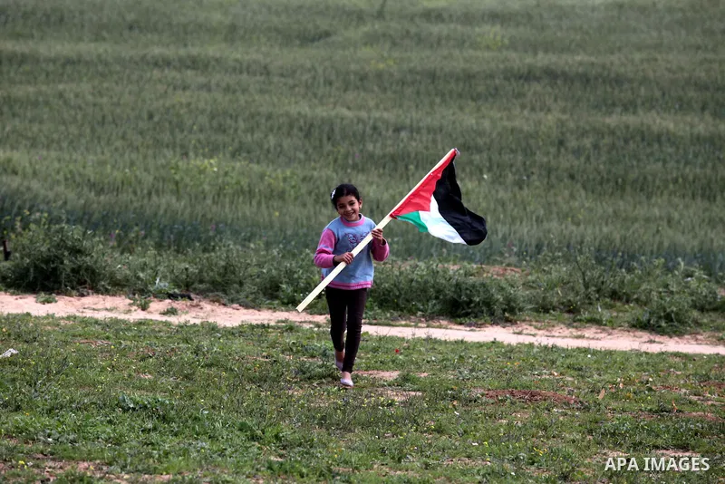 A Palestinian girl holds a Palestine flag during a rally marking Land Day in Jabalya in the northern Gaza Strip on March 30, 2014. The annual demonstrations mark the deaths of six Arab Israeli protesters at the hands of...