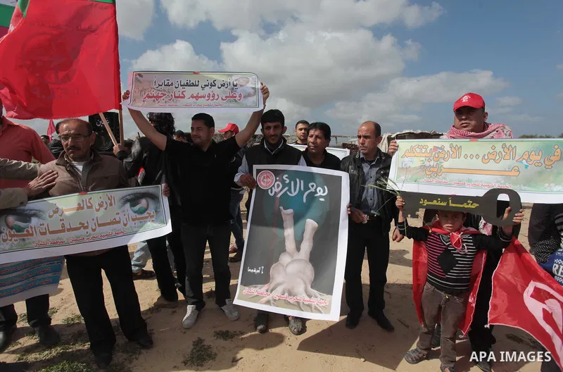 Palestinian supporters of the Popular Front for the Liberation of Palestine hold banner and national flags during a rally marking Land Day in Jabalya in the northern Gaza Strip on March 30, 2014. The annual demonstration...