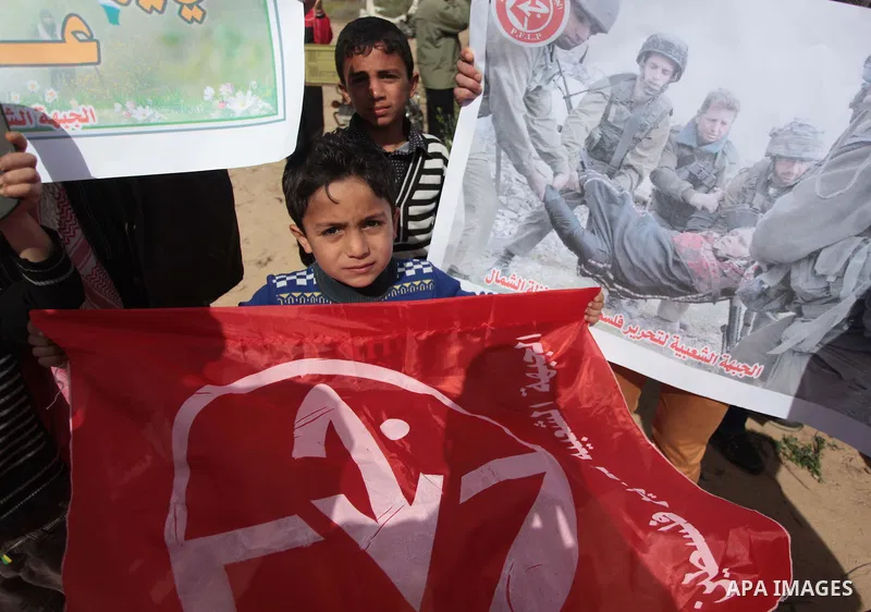 Palestinian supporters of the Popular Front for the Liberation of Palestine hold banner and national flags during a rally marking Land Day in Jabalya in the northern Gaza Strip on March 30, 2014. The annual demonstration...