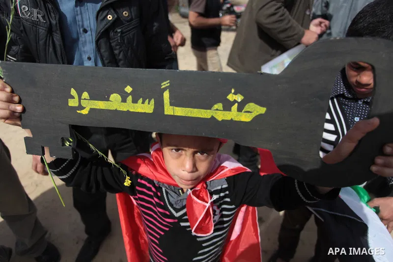 Palestinian supporters of the Popular Front for the Liberation of Palestine hold banner and national flags during a rally marking Land Day in Jabalya in the northern Gaza Strip on March 30, 2014. The annual demonstration...