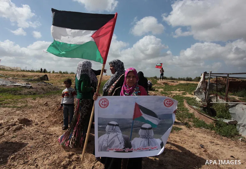 Palestinian supporters of the Popular Front for the Liberation of Palestine hold banner and national flags during a rally marking Land Day in Jabalya in the northern Gaza Strip on March 30, 2014. The annual demonstration...