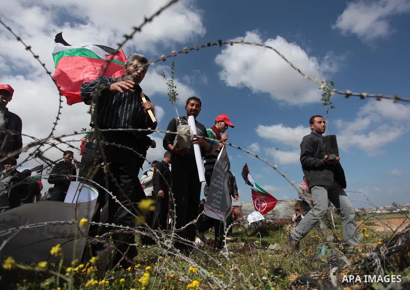 Palestinian supporters of the Popular Front for the Liberation of Palestine hold banner and national flags during a rally marking Land Day in Jabalya in the northern Gaza Strip on March 30, 2014. The annual demonstration...