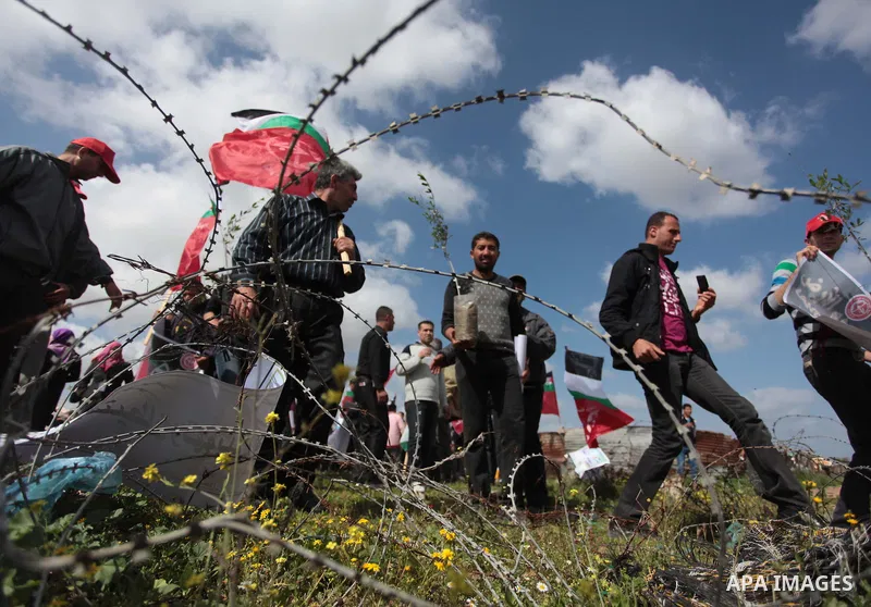 Palestinian supporters of the Popular Front for the Liberation of Palestine hold banner and national flags during a rally marking Land Day in Jabalya in the northern Gaza Strip on March 30, 2014. The annual demonstration...