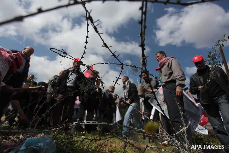 Palestinian supporters of the Popular Front for the Liberation of Palestine hold banner and national flags during a rally marking Land Day in Jabalya in the northern Gaza Strip on March 30, 2014. The annual demonstration...