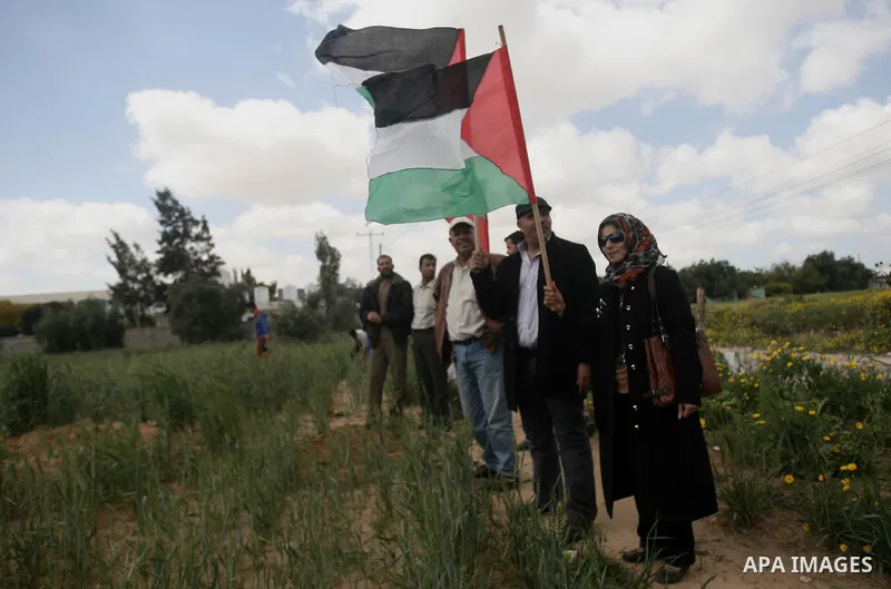 Palestinians hold national flags during a rally marking Land day in Khan Younis southern Gaza strip, on March 30, 2014. The annual demonstrations mark the deaths of six Arab Israeli protesters at the hands of Israeli pol...