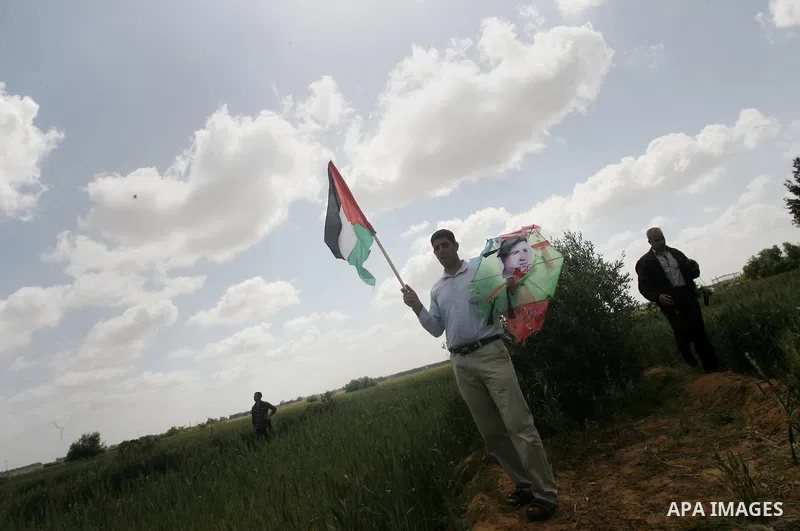 A Palestinian holds national flag during a rally marking Land day in Khan Younis southern Gaza strip, on March 30, 2014. The annual demonstrations mark the deaths of six Arab Israeli protesters at the hands of Israeli po...