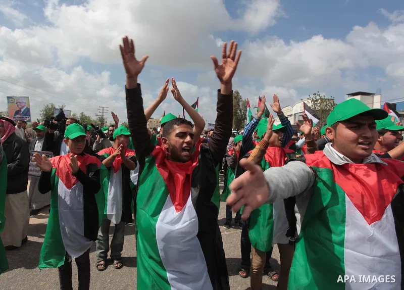 Protesters wear Palestinian flags as they shout during a protest marking Land Day in the northern Gaza Strip March 30, 2014. The annual demonstrations mark the deaths of six Arab Israeli protesters at the hands of Israel...