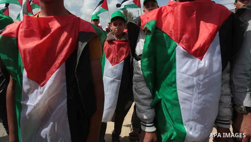 Protesters wear Palestinian flags as they shout during a protest marking Land Day in the northern Gaza Strip March 30, 2014. The annual demonstrations mark the deaths of six Arab Israeli protesters at the hands of Israel...