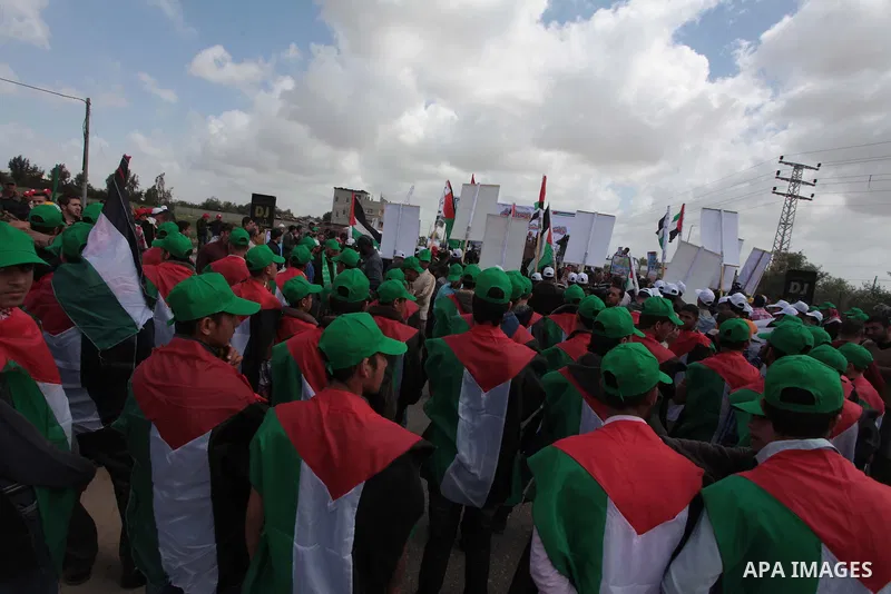 Protesters wear Palestinian flags as they shout during a protest marking Land Day in the northern Gaza Strip March 30, 2014. The annual demonstrations mark the deaths of six Arab Israeli protesters at the hands of Israel...