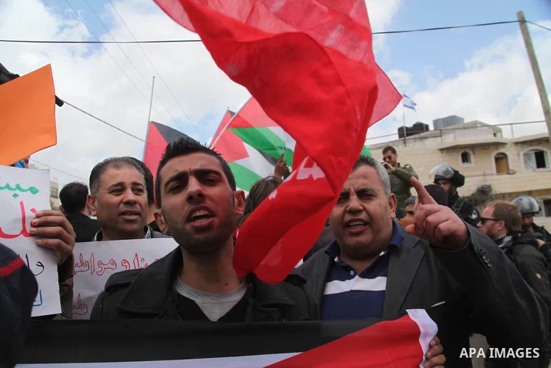 Palestinians protest near an Israeli-occupied Palestinian home, located close to the Kiryat Arbaa Jewish settlment, as Palestinians across the Israeli occupied West Bank and the Gaza Strip commemorate Land Day on March 3...