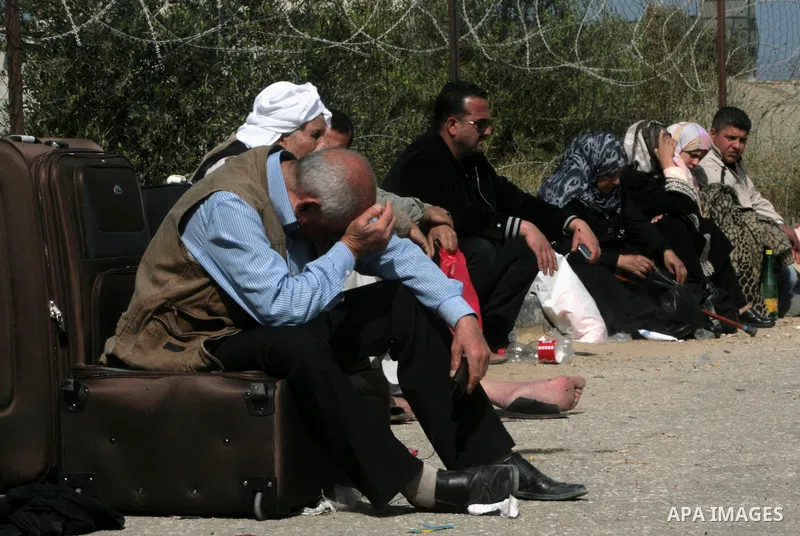 Palestinians wait to cross into Egypt at the Rafah border crossing between Egypt and the southern Gaza Strip on March 30, 2014. The Gaza Strip's land border with Egypt reopened after a 50-day closure, but only for three...
