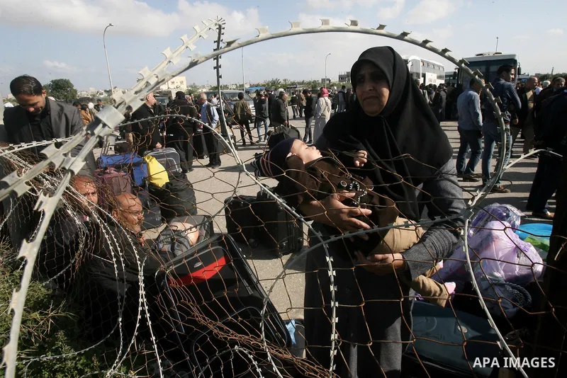 Palestinians wait to cross into Egypt at the Rafah border crossing between Egypt and the southern Gaza Strip on March 30, 2014. The Gaza Strip's land border with Egypt reopened after a 50-day closure, but only for three...