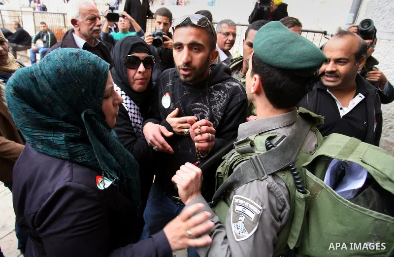 Palestinian protesters argue with an Israeli security officer during a march marking the Land Day in Jerusalem's old city, Sunday, March 29, 2014. The Land Day commemorates the Israeli government expropriation of thousan...
