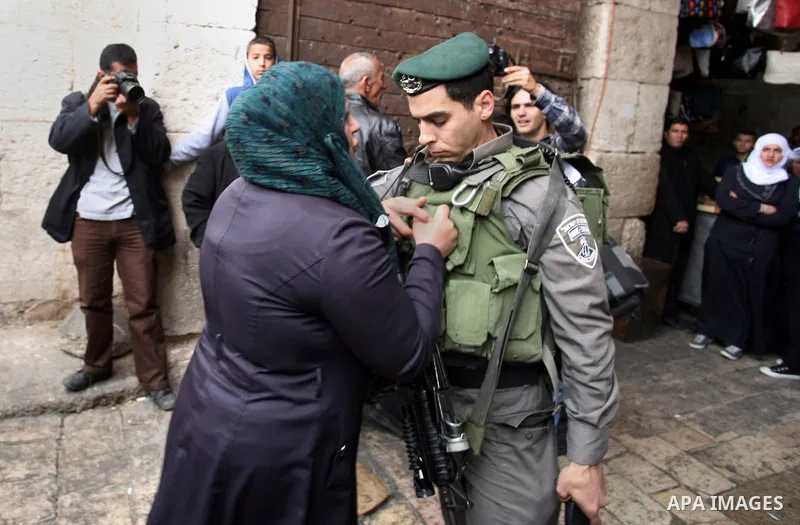 A Palestinian woman squabbles with an Israeli security officer during a march marking the Land Day in Jerusalem's old city, Sunday, March 29, 2014. The Land Day commemorates the Israeli government expropriation of thousa...