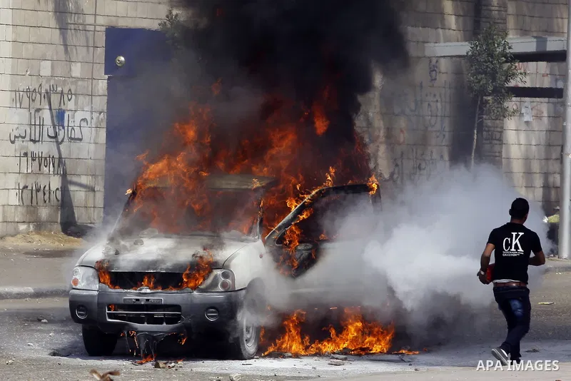An Egyptian man tries to extinguish a police car set on fire by students of Al-Azhar University, who are supporters of the Muslim Brotherhood and deposed President Mohamed Mursi, during clashes with riot police at the un...