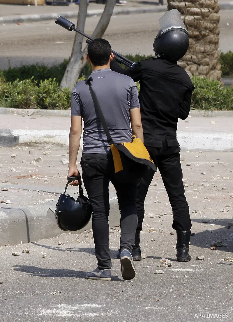 An Egyptian riot policeman fires tear gas towards students of Al-Azhar University, who are supporters of the Muslim Brotherhood and deposed President Mohamed Mursi, during clashes at the university's campus in Cairo's Na...