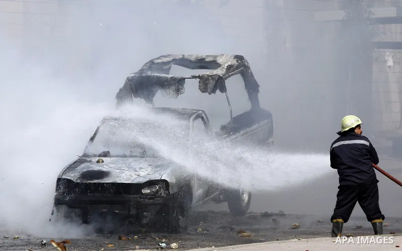 An Egyptian civil defense officer tries to extinguish a police car set on fire by students of Al-Azhar University, who are supporters of the Muslim Brotherhood and deposed President Mohamed Mursi, during clashes with rio...