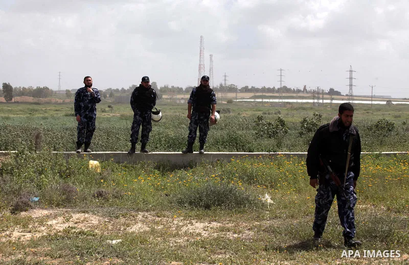 Palestnian border policemen stand guard in front of protesters (unseen) during a protest marking Land Day at the border between Israel and Gaza Strip, on March 30, 2014. March 30 marks Land Day, the annual commemoration...
