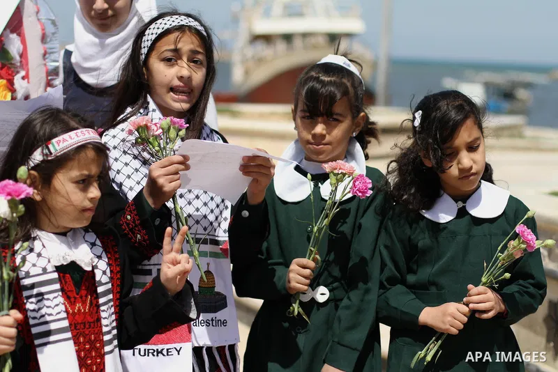 Palestinian girls carry flowers as they celebrate, at seaport Gaza city, on March 31, 2014, the victory of Turkish Prime Minister, Recep Tayyip Erdogan in the local elections. Photo by Mohammed Asad