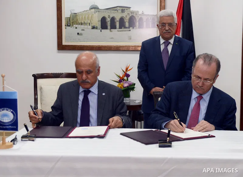 Palestinian President Mahmoud Abbas signs an agreement with the Foundation Ofed at Abass's office in the West Bank city of Ramallah on March 31, 2014. Photo by Thaer Ganaim