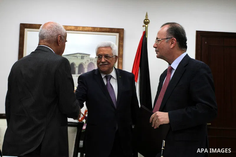 Palestinian President Mahmoud Abbas shakes hands with Suleiman Herbash, the Director-General of the OPEC Fund for International Development during a signing ceremony with his foundation to support Palestinian students in...
