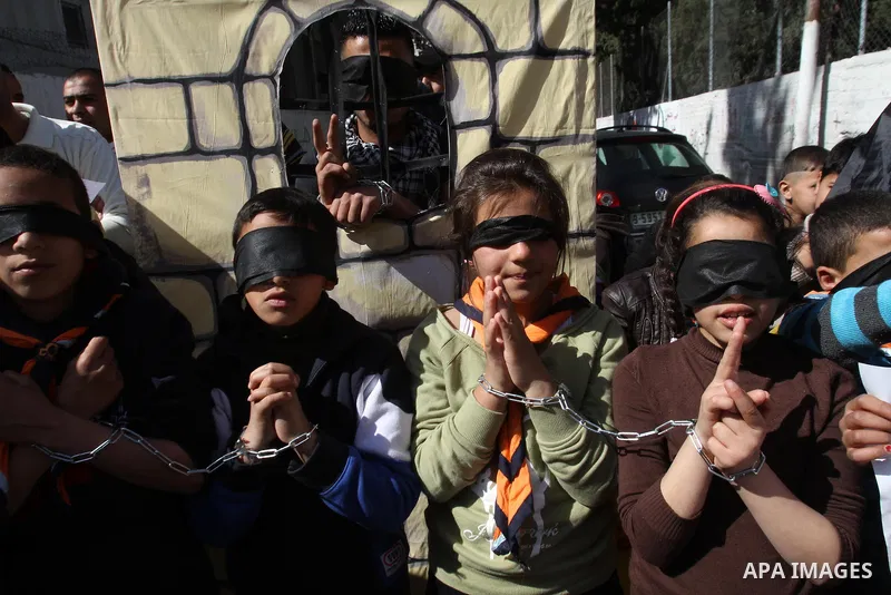 Palestinian children with hands chained take part in a protest demanding the U.S. Secretary of State John Kerry to work for release Palestinian prisoners in Israeli jails, at Balata refugee camp near the West Bank city o...