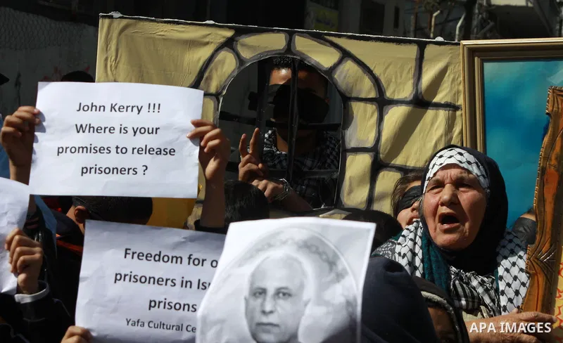 Palestinians hold placards during a protest demanding the U.S. Secretary of State John Kerry to work for release Palestinian prisoners in Israeli jails, at Balata refugee camp near the West Bank city of Nablus, March 31,...