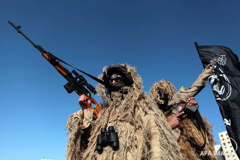 Masked militants of Al-Nasser brigades, the military wing of the Popular Resistance Committees, march with weapons during an anti-Israeli protest in Gaza City March 31, 2014. Photo by Ashraf Amra