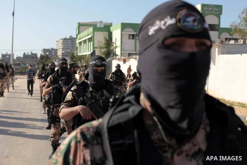 Masked militants of Al-Nasser brigades, the military wing of the Popular Resistance Committees, march with weapons during an anti-Israeli protest in Gaza City March 31, 2014. Photo by Ashraf Amra
