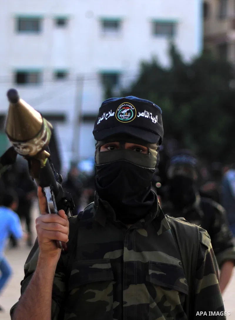 Masked militants of Al-Nasser brigades, the military wing of the Popular Resistance Committees, march with weapons during an anti-Israeli protest in Gaza City March 31, 2014. Photo by Khaled al-Sabbah