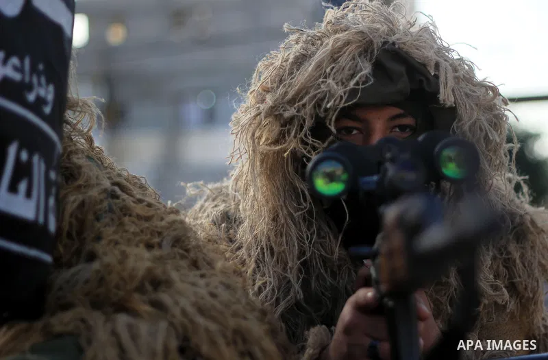 Masked militants of Al-Nasser brigades, the military wing of the Popular Resistance Committees, march with weapons during an anti-Israeli protest in Gaza City March 31, 2014. Photo by Khaled al-Sabbah
