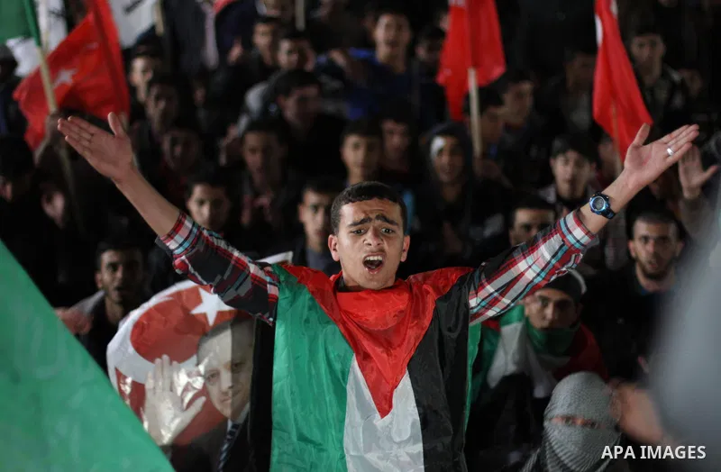 Palestinian supporters of Hamas movement hold placards and turkish flags during a rally to celebrate the the victory of Turkey's Prime Minister Recep Tayyip Erdogan in the local turkish elections, in the northern Gaza St...