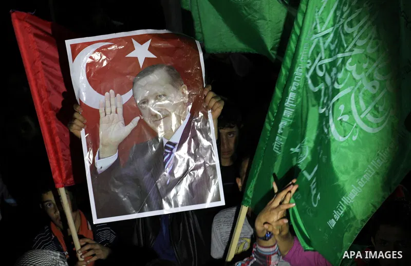 Palestinian supporters of Hamas movement hold placards and turkish flags during a rally to celebrate the the victory of Turkey's Prime Minister Recep Tayyip Erdogan in the local turkish elections, in the northern Gaza St...