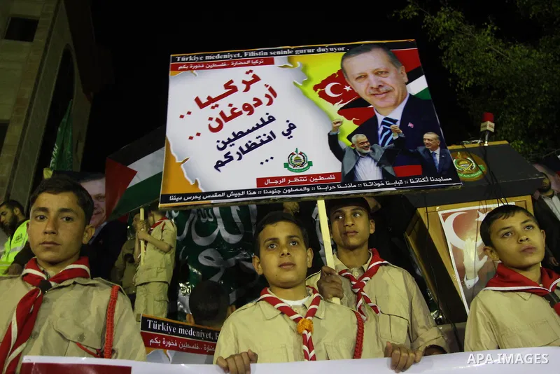 Palestinian supporters of Hamas movement hold placards and turkish flags during a rally to celebrate the the victory of Turkey's Prime Minister Recep Tayyip Erdogan in the local turkish elections, in the northern Gaza St...