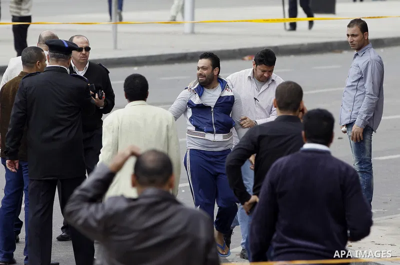Egyptian security forces detain a person after multiple explosions hit the area outside the main campus of Cairo University, killing at least two, in Giza, Egypt, Wednesday, April 2, 2014. The bombings targeted riot poli...