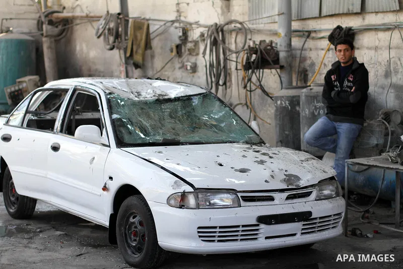 A Palestinian man stands next to a damaged car following an overnight Israeli air strike on Jabalia in the northern Gaza Strip, on April 4, 2014. After Israel called off the planned release of 26 Palestinian prisoners th...