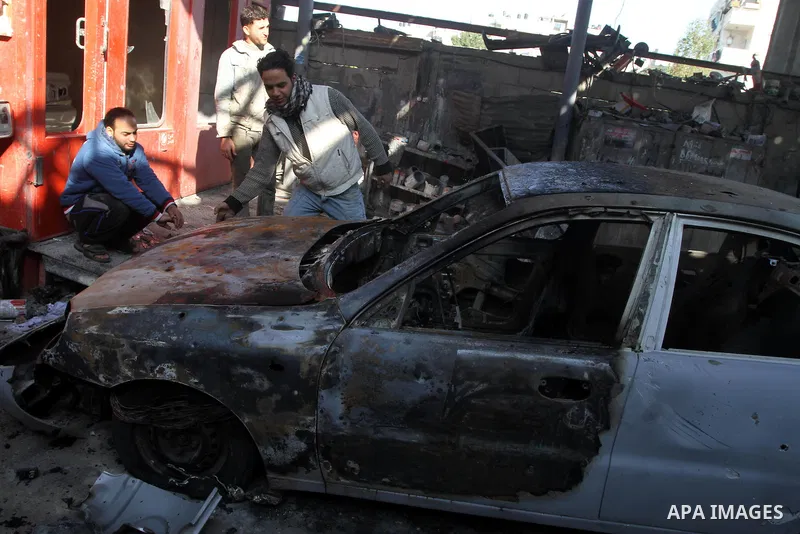 A Palestinian man inspects a burnt out car following an overnight Israeli air strike on Jabalia in the northern Gaza Strip, on April 4, 2014. After Israel called off the planned release of 26 Palestinian prisoners the da...