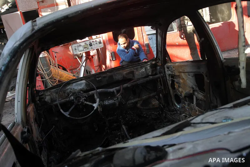 A Palestinian man inspects a burnt out car following an overnight Israeli air strike on Jabalia in the northern Gaza Strip, on April 4, 2014. After Israel called off the planned release of 26 Palestinian prisoners the da...