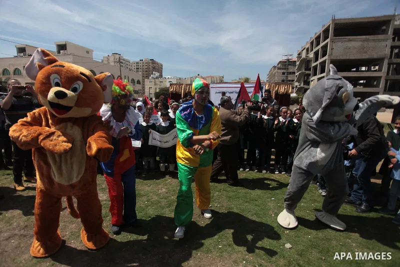 Palestinian clowns play with children in a rally marking the Children's Day during a protest against Israeli blockade on Gaza strip in Gaza city, on April 05, 2014. Photo by Ashraf Amra