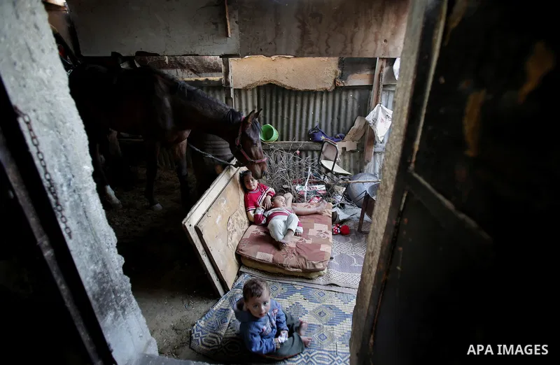 Palestinian children play outside their house, in Gaza city on April 05, 2014. Marking children's day, statistics show 50% of the population of the Gaza Strip under 18 years, 56% of them Living in poverty. Photo by Ezz a...
