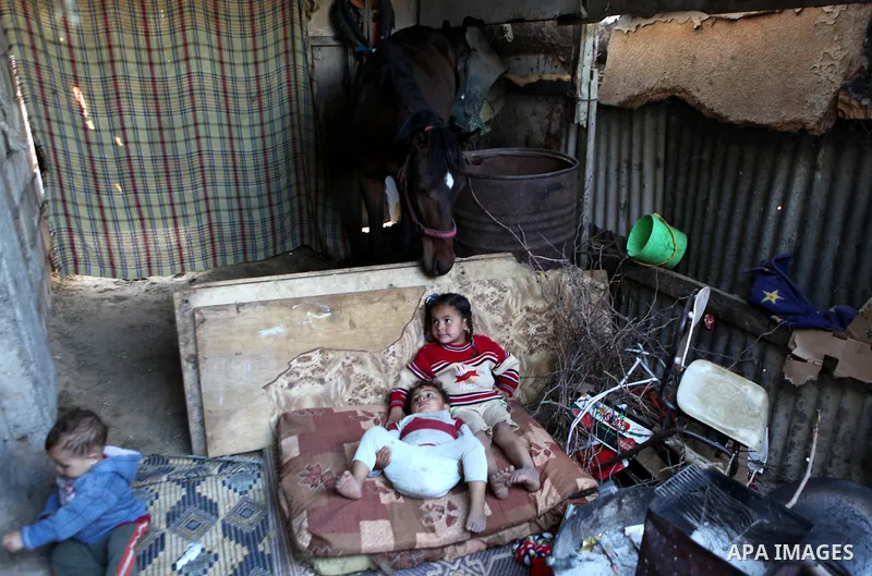 Palestinian children play outside their house, in Gaza city on April 05, 2014. Marking children's day, statistics show 50% of the population of the Gaza Strip under 18 years, 56% of them Living in poverty. Photo by Ezz a...