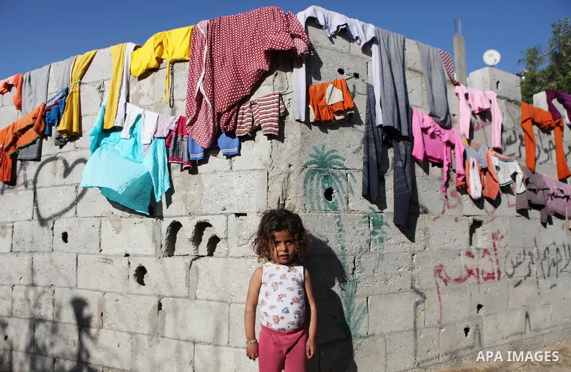 Palestinian children play outside their house, in Gaza city on April 05, 2014. Marking children's day, statistics show 50% of the population of the Gaza Strip under 18 years, 56% of them Living in poverty. Photo by Ezz a...