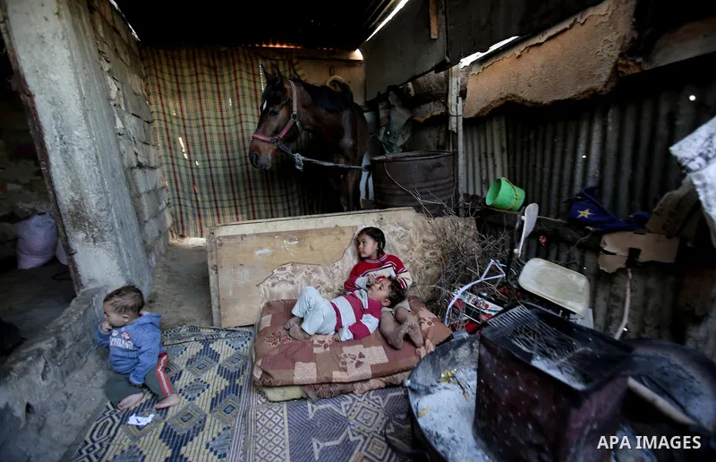 Palestinian children play outside their house, in Gaza city on April 05, 2014. Marking children's day, statistics show 50% of the population of the Gaza Strip under 18 years, 56% of them Living in poverty. Photo by Ezz a...