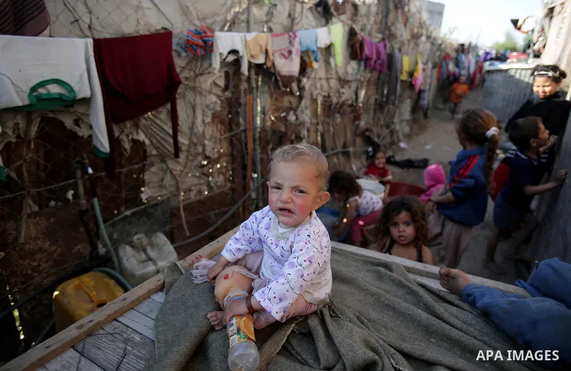 Palestinian children play outside their house, in Gaza city on April 05, 2014. Marking children's day, statistics show 50% of the population of the Gaza Strip under 18 years, 56% of them Living in poverty. Photo by Ezz a...