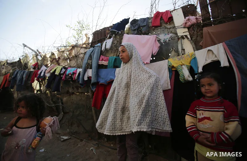 Palestinian children play outside their house, in Gaza city on April 05, 2014. Marking children's day, statistics show 50% of the population of the Gaza Strip under 18 years, 56% of them Living in poverty. Photo by Ezz a...