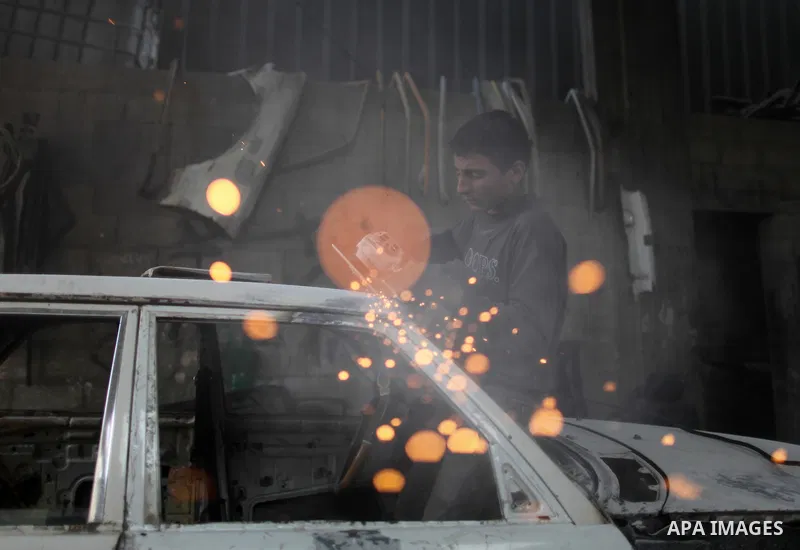 Twelve-year-old Palestinian boy Saher Totah works in a car workshop in Gaza City on April 7, 2014. There are about 65,000 working children in the Palestinian territories, accounting for 6% of all children at 5-14, accord...
